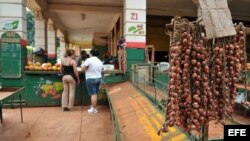 ARCHIVO. Dos mujeres compran cebollas en un agromercado en La Habana.