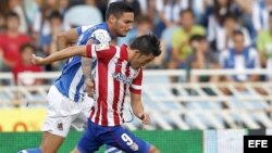 El delantero del Atlético de Madrid David Villa (d) es perseguido por el defensa francés de la Real Sociedad Liassine Cadamuro.