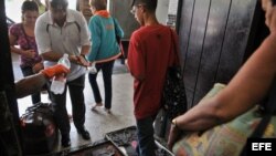 Viajeros pasan por un control sanitario en la terminal de ómnibus en La Habana tras informarse de casos de cólera. 